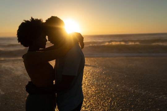 couple at the beach hugging in the sunset